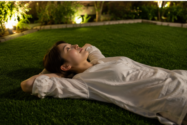 人工芝の上でリラックスしながら夜空を見上げる様子